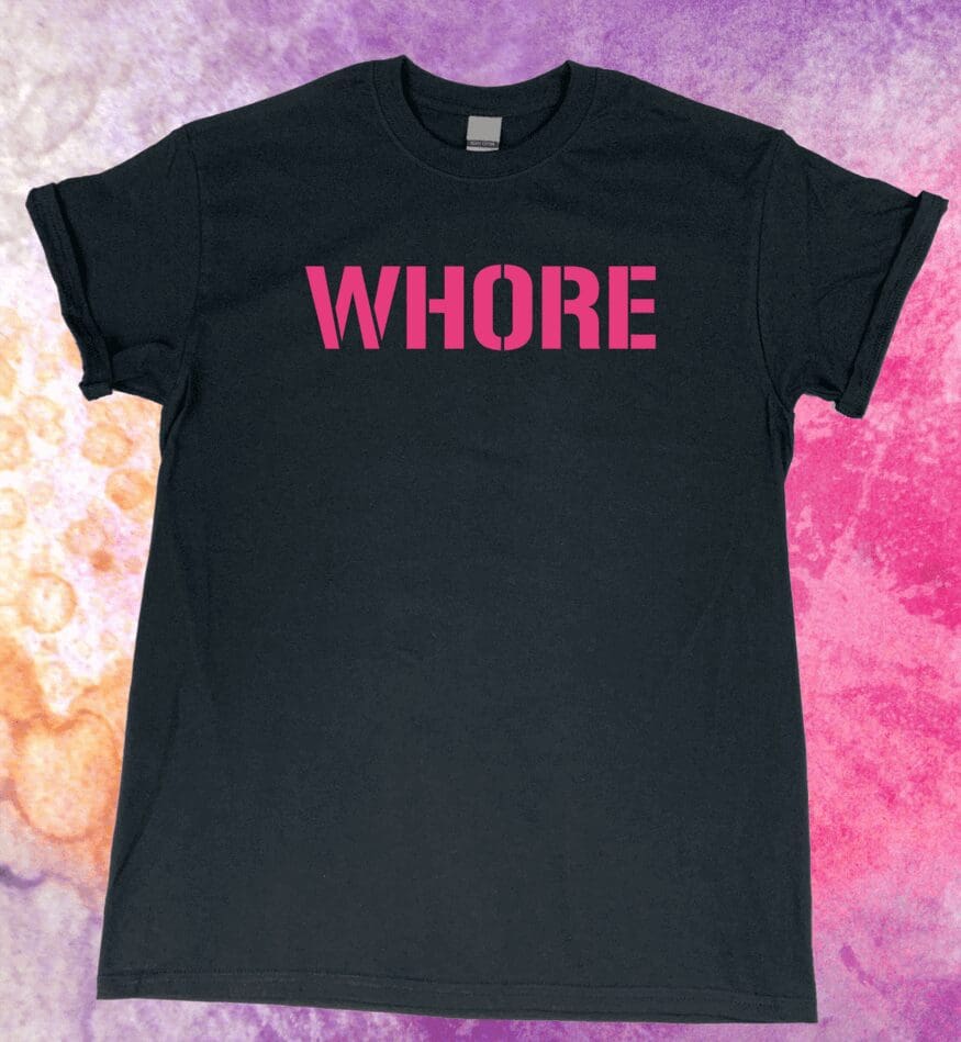 A black t-shirt with the word " whore " written in pink.